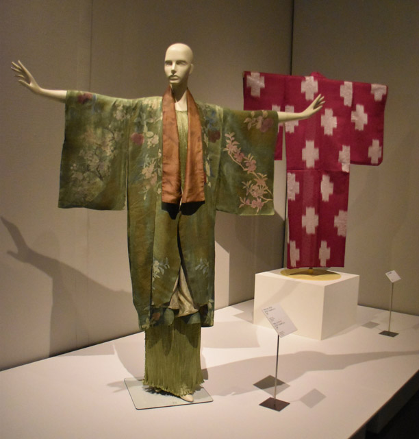 3章「日本と西洋のファッション」にて。（手前）マリアノ・フォルチュニの「デルフォス」ドレス（1920年頃）と、「キモノ」ジャケット（1925年頃）。　（後ろ）日本の水玉入り十字絣着物（1910年代）