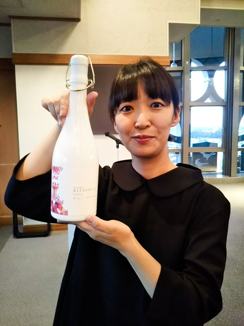 「NIIZAWA KIZASHI 純米大吟醸 2019」を持つ荒神明香さん